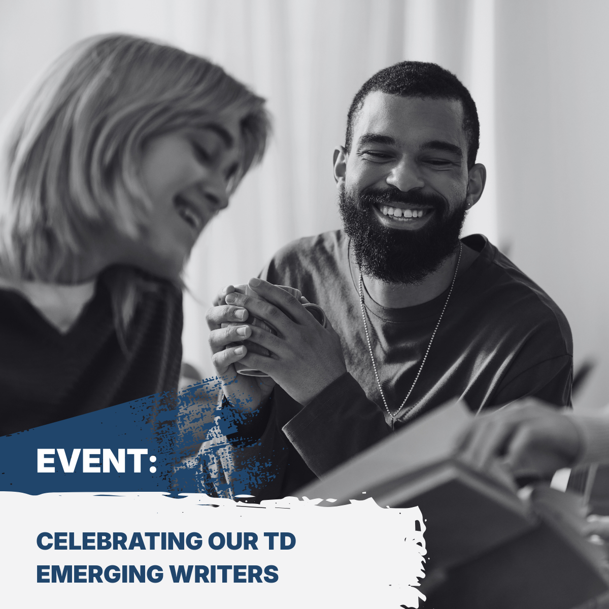 Image of two peole sitting at a table looking down at a book