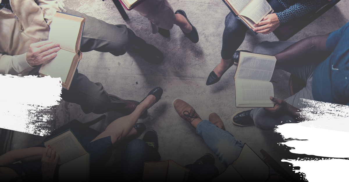 Group of people sitting in a circle with books on their laps